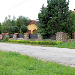 Fencing of a family house with a forged gate with a metal panel from UKOVMI